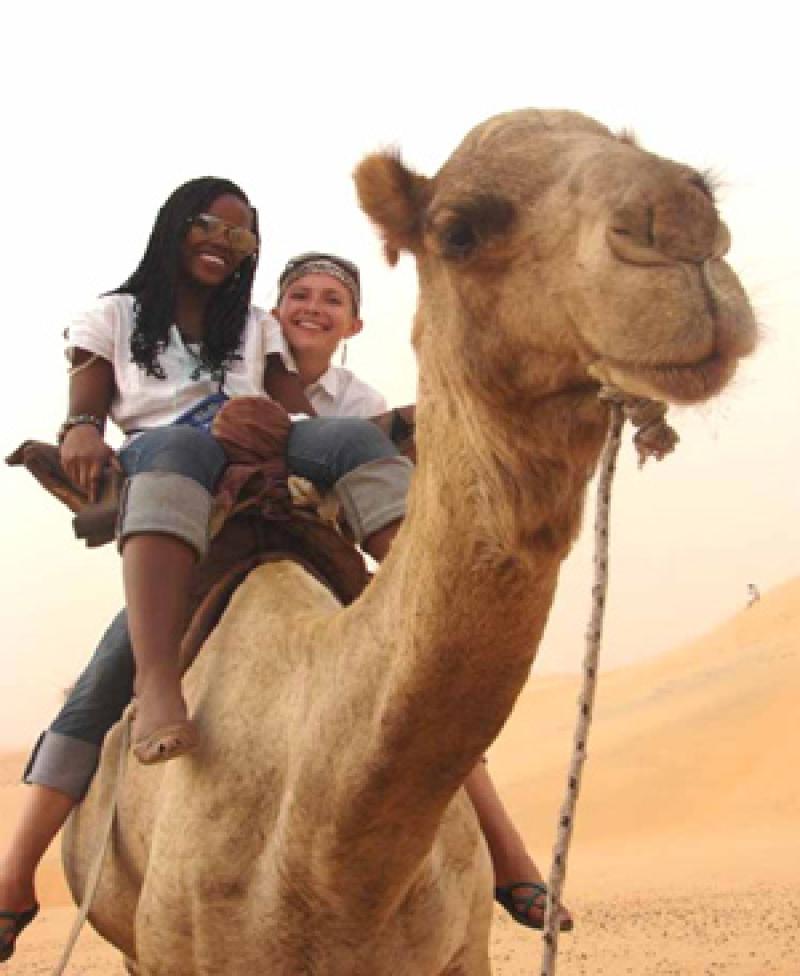 Devyn (right) riding a camel with fellow student, Zawadi Baharanyi, in the Lompoul Desert, In SENEGAL (Photo by Tiana Hallberg).