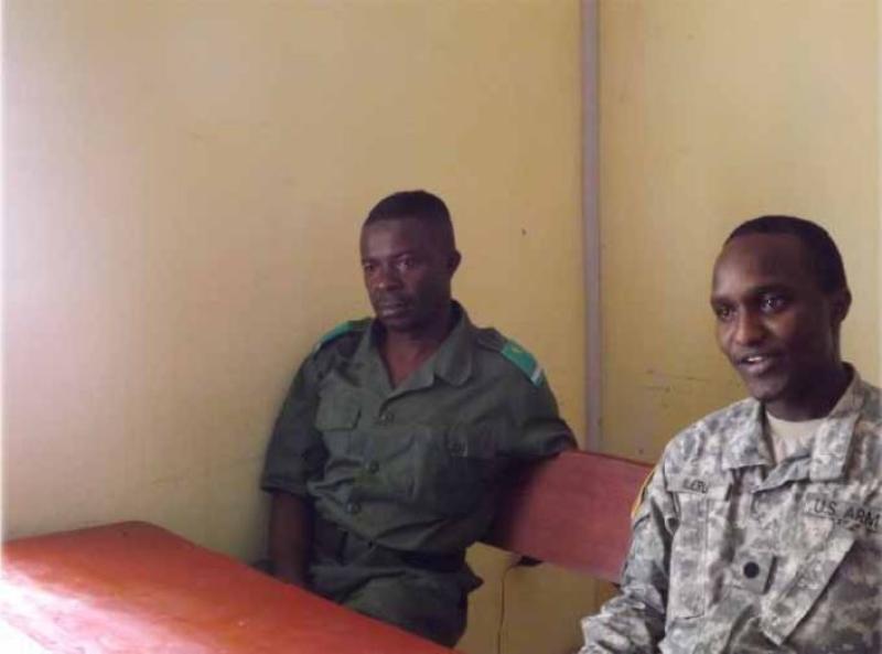Patrick Njeru sits beside a foreign soldier.