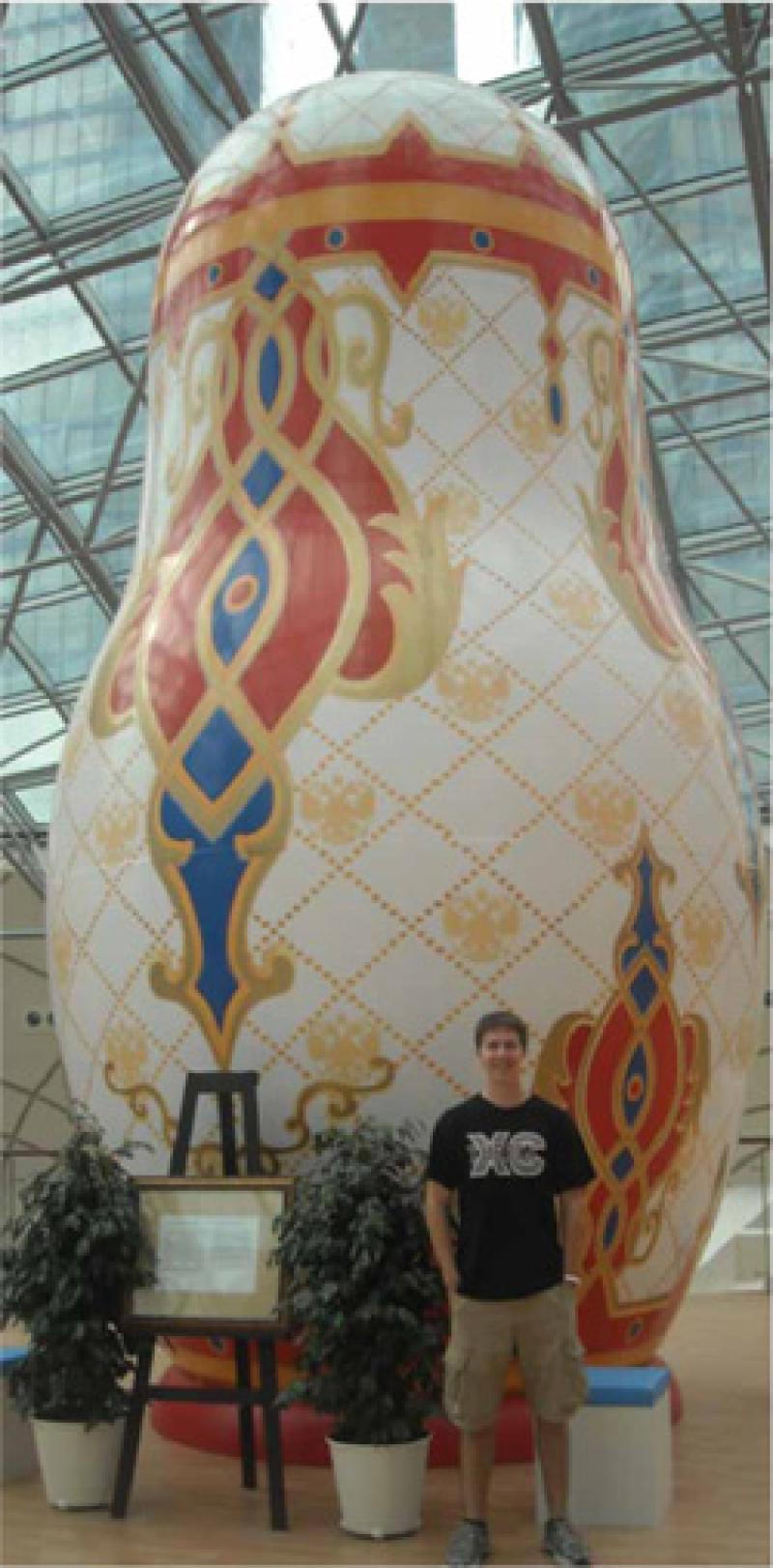 Alex Polivka in front of a gigantic Russian doll.