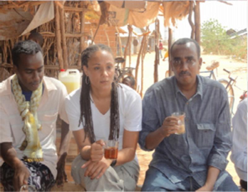 Mr. Abdullahi enjoys drinking local tea with American hip-hop artist Mama Sol and local man in the field. Mr. Abdullahi enjoys drinking local tea with American hip-hop artist Mama Sol and local man in the field.