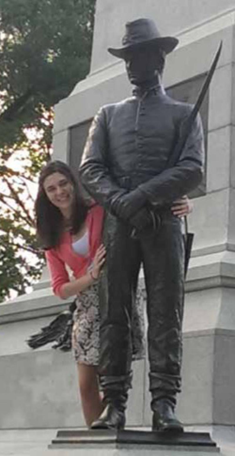 Jessica Bachman poses for a picture next to a statue.