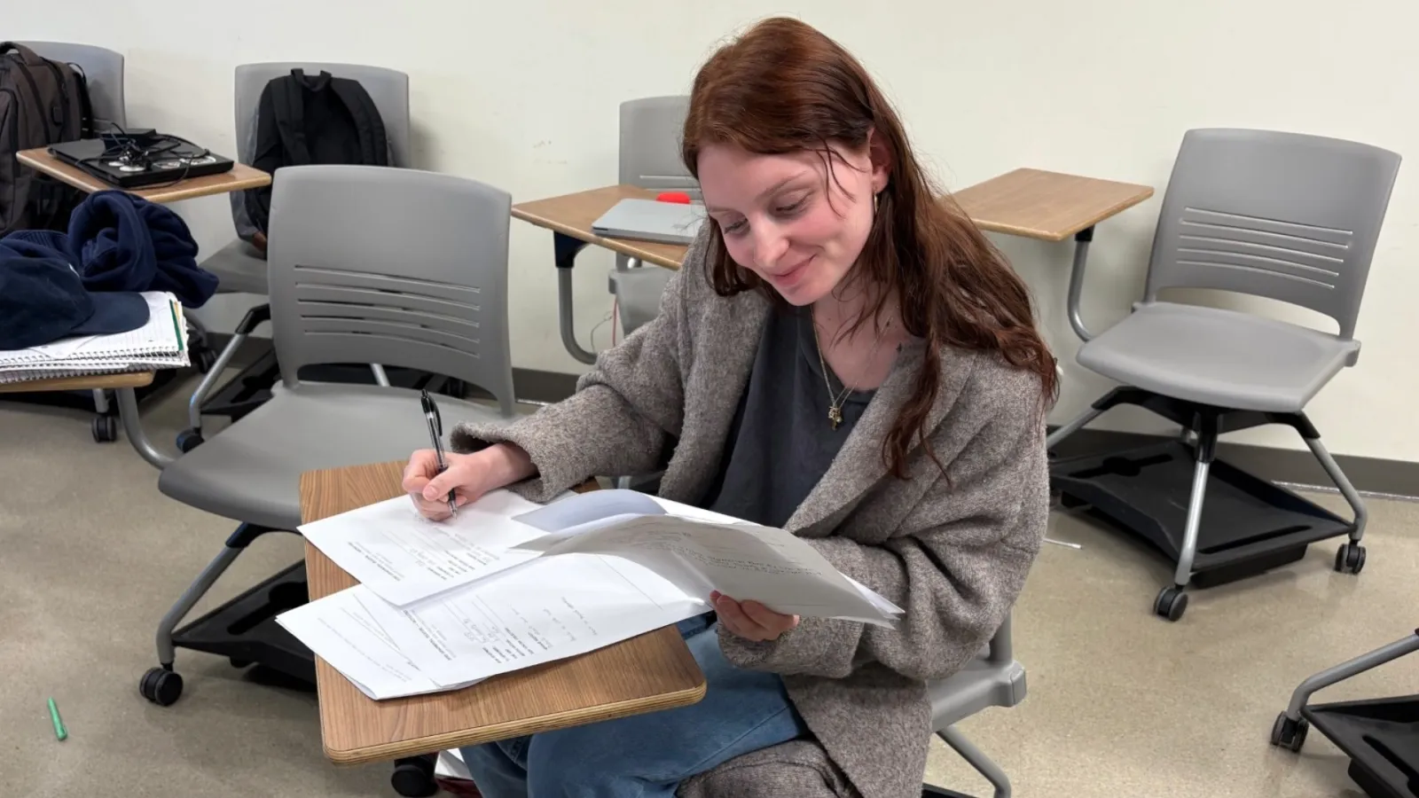 A student writing on paper at a desk