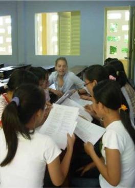 Student teaches young Asian girls English.