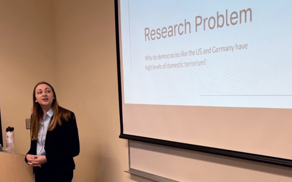 A student presents a research project in front of a projector
