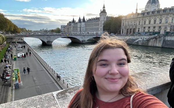 A student taking a selfie on a bridge in Paris, France