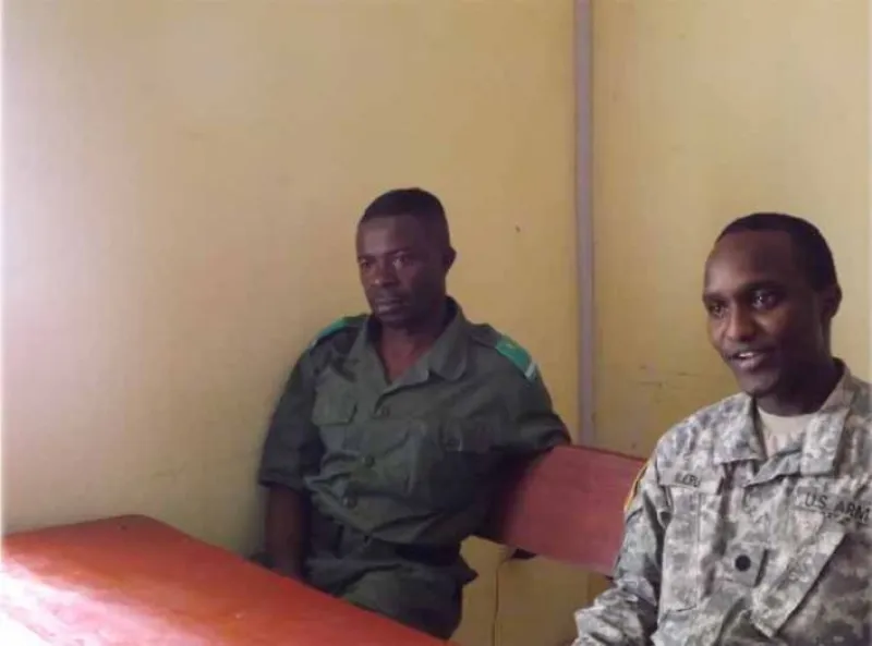 Patrick Njeru sits beside a foreign soldier.