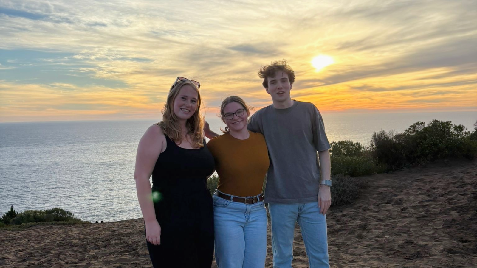 3 students in front of a sunset in Chile