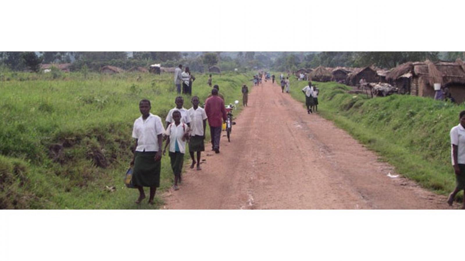 Villagers walk along an African road.