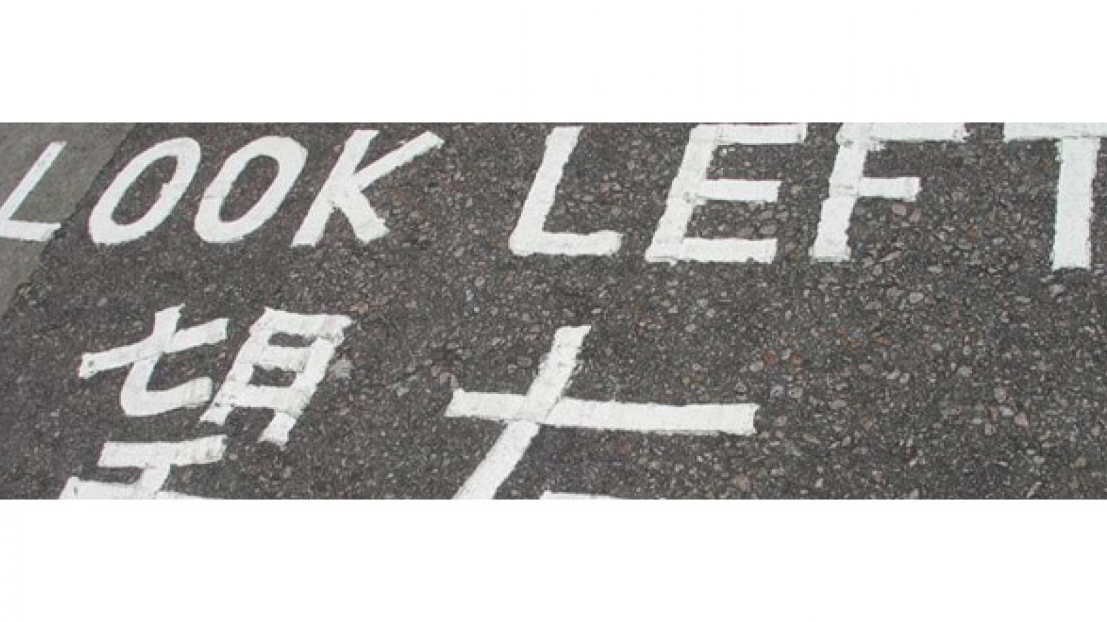 The words Look Left painted on a road in two languages.